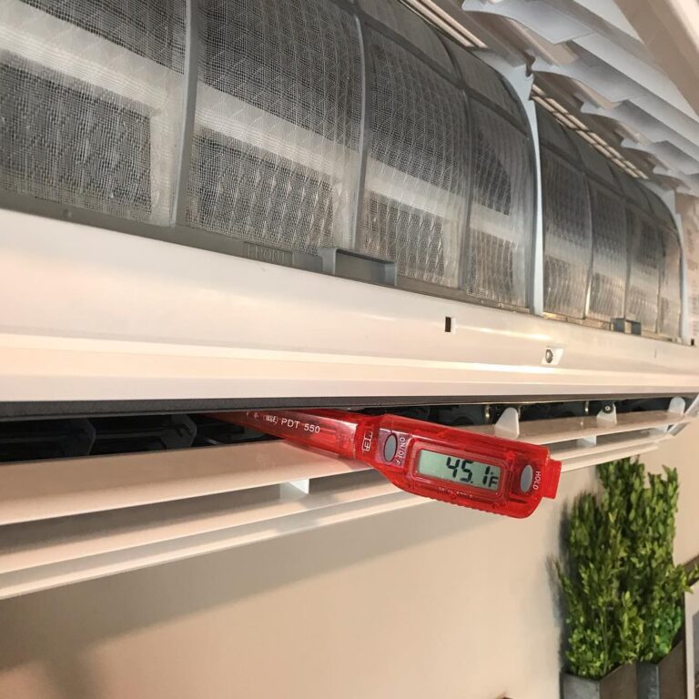 red thermometer checking temp coming out of AC unit.